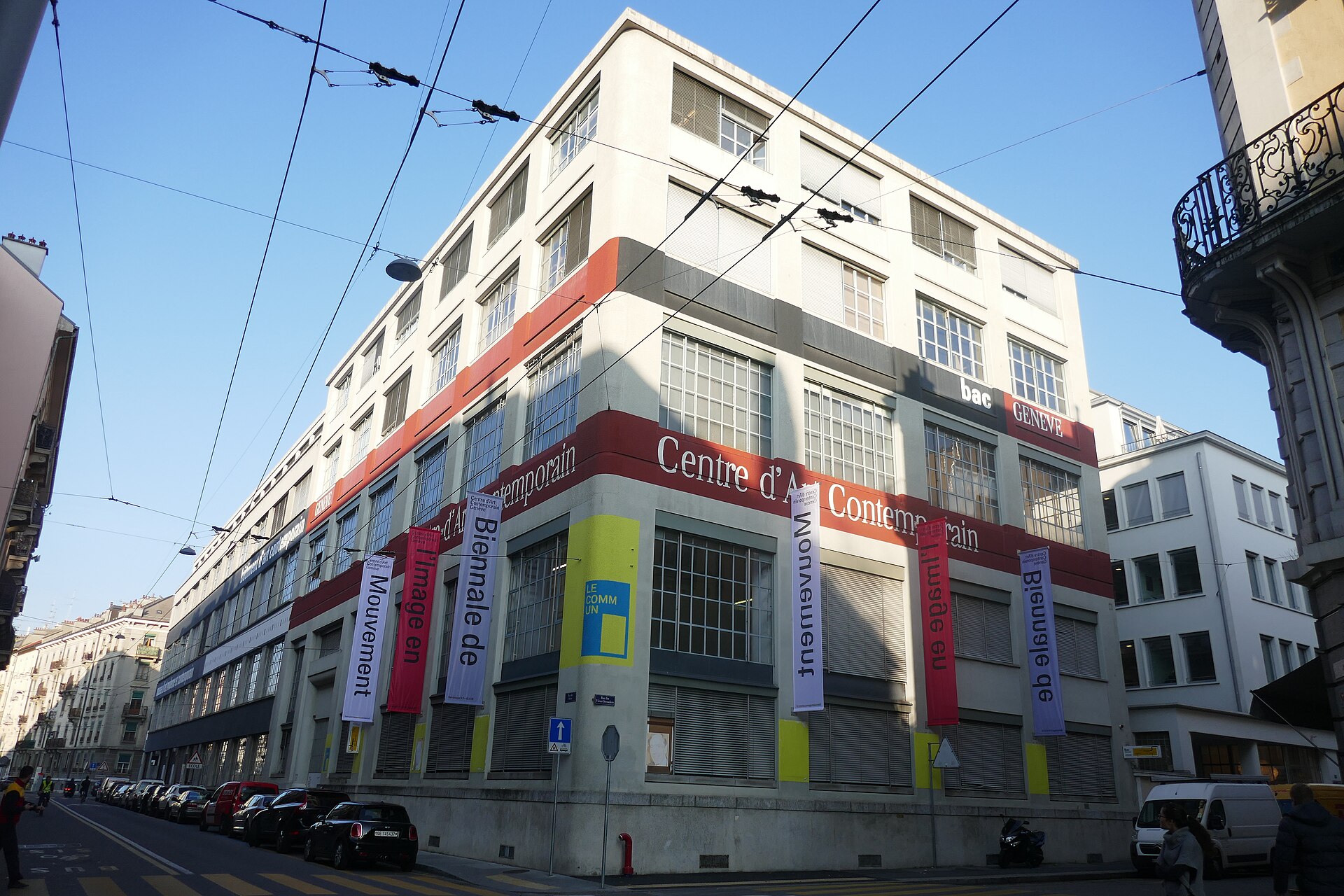 Exhibition banners hang beneath the Centre d'Art Contemporain lettering on a large corner building in Geneva's arts district.