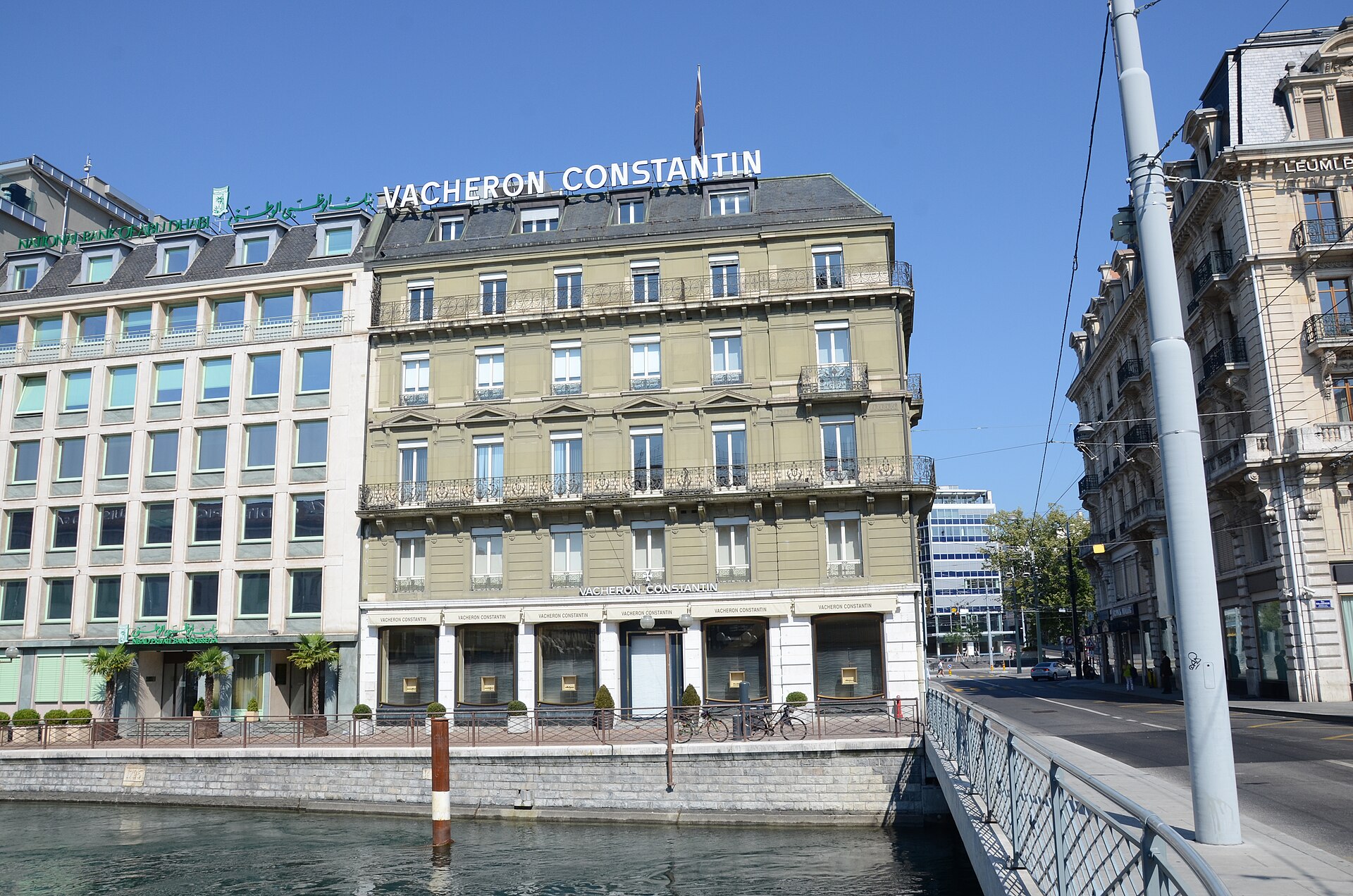 The Vacheron Constantin building on the Quai de l'Île in Geneva, with the company name on the roof, beside the Rhône and a bridge