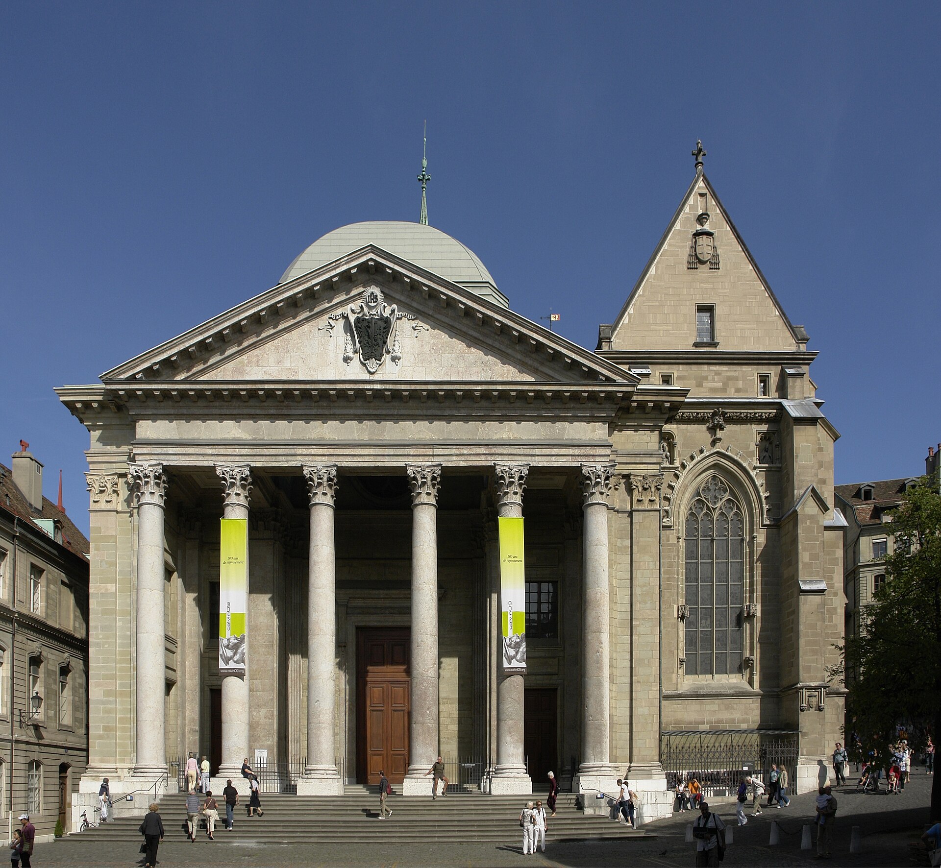 The neoclassical columned portico of St Pierre Cathedral in Geneva, with the Gothic Chapel of the Maccabees beside it under a blue sky