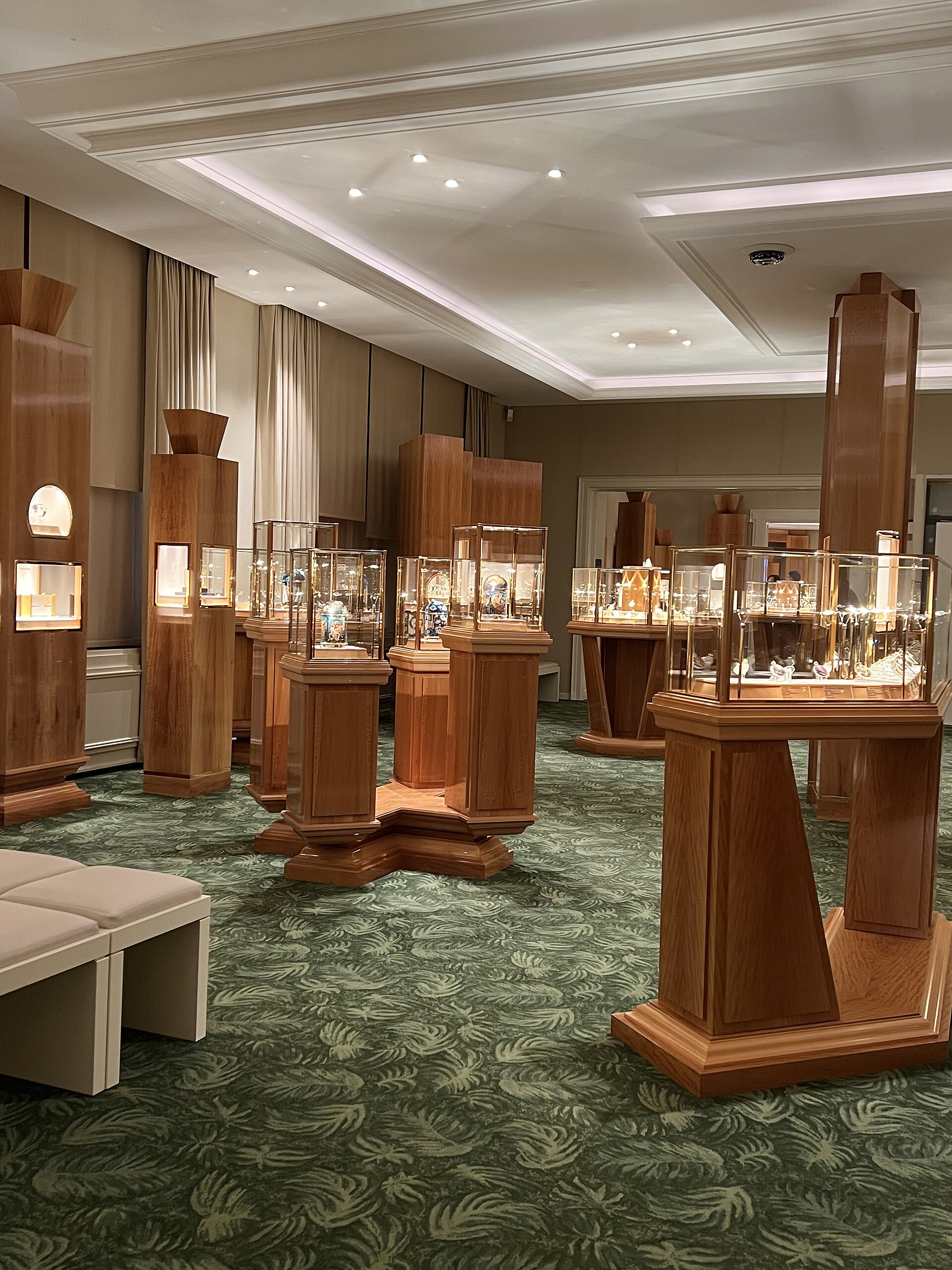Glass display cases of antique watches in a wood-panelled gallery of the Patek Philippe Museum in Geneva