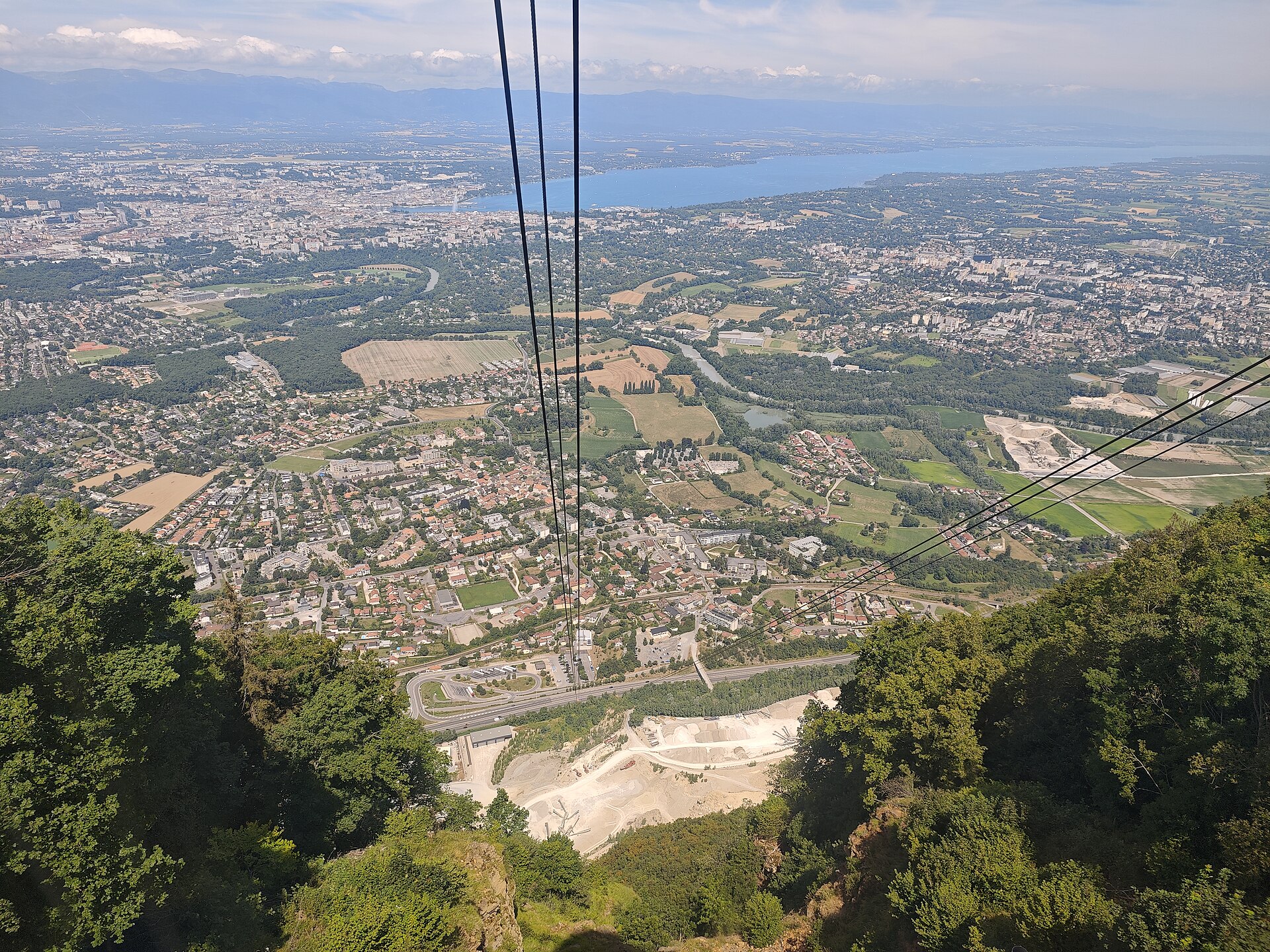 The view down the Salève cable car's cables over the suburbs of Geneva to the city and the lake