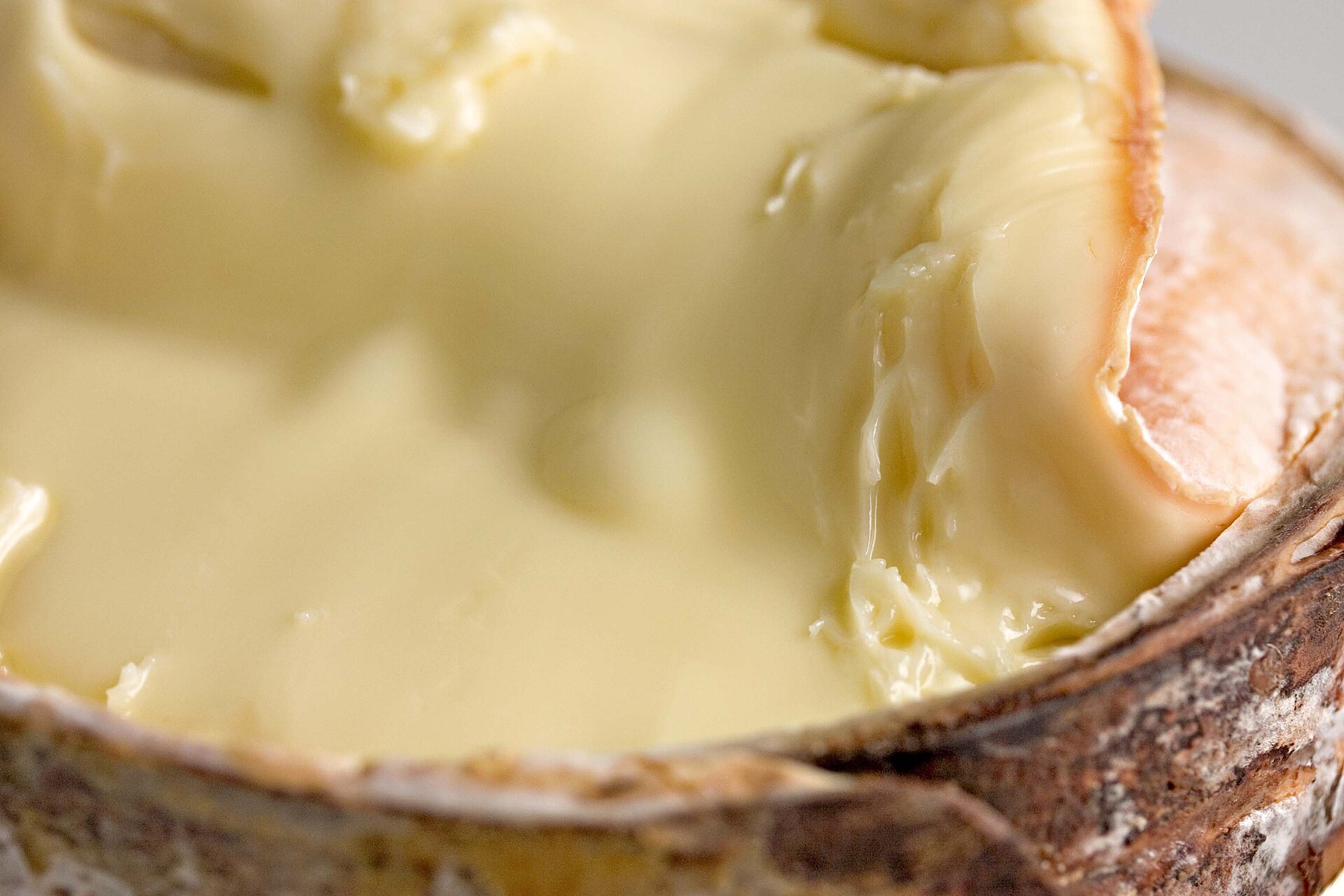 A Vacherin Mont-d'Or cheese opened in its spruce-bark band, with a soft, creamy interior
