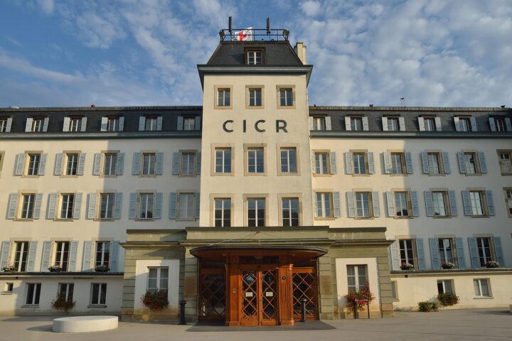 The ICRC headquarters in Geneva displays large CICR letters above its entrance and a Red Cross flag on the roof.