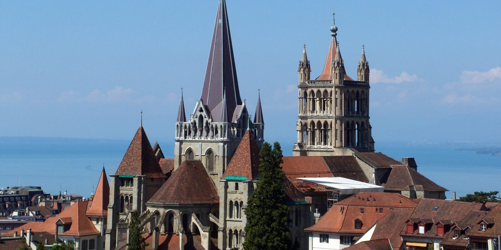 Lausanne Cathedral towers above the old town’s red roofs, with the blue waters of Lake Geneva behind.