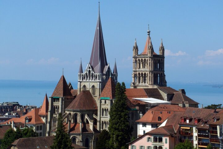 Lausanne Cathedral towers above the old town’s red roofs, with the blue waters of Lake Geneva behind.