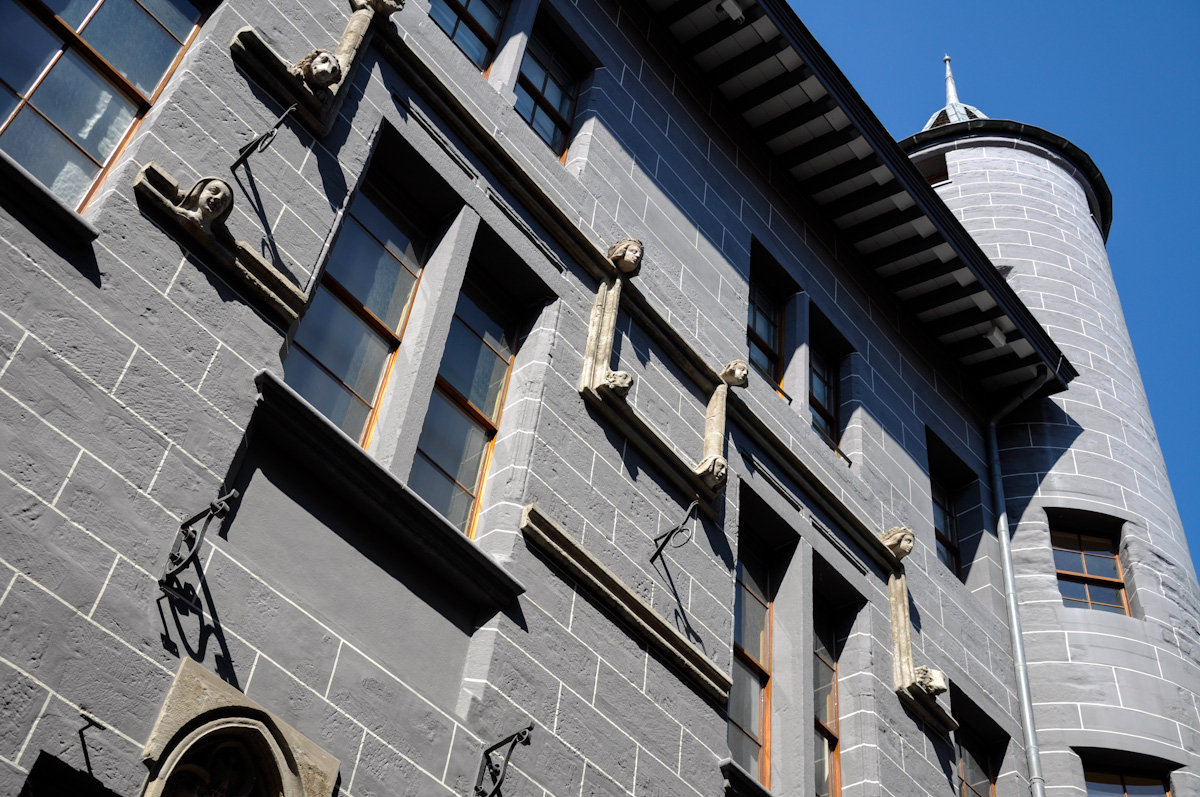 Maison Tavel's carved window surrounds and round corner turret rise against a blue sky in Geneva Old Town.