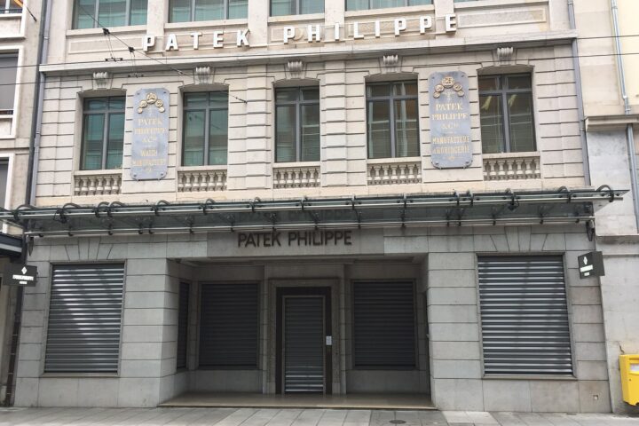 Patek Philippe lettering and gold watch manufactory plaques mark the stone facade of its Rue du Rhône building in Geneva.