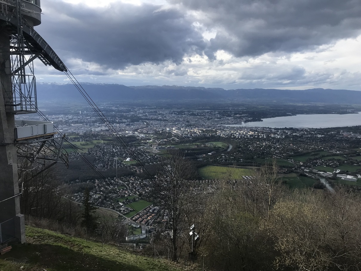 The Salève upper cable-car station overlooks Geneva, the winding Arve and Lake Geneva beneath heavy clouds.