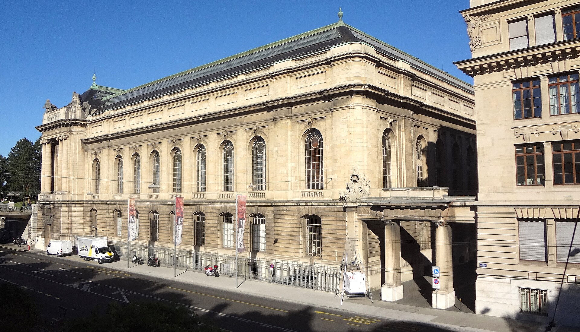 Tall arched windows and MAH banners line Geneva’s Museum of Art and History above Boulevard Emile-Jaques-Dalcroze.