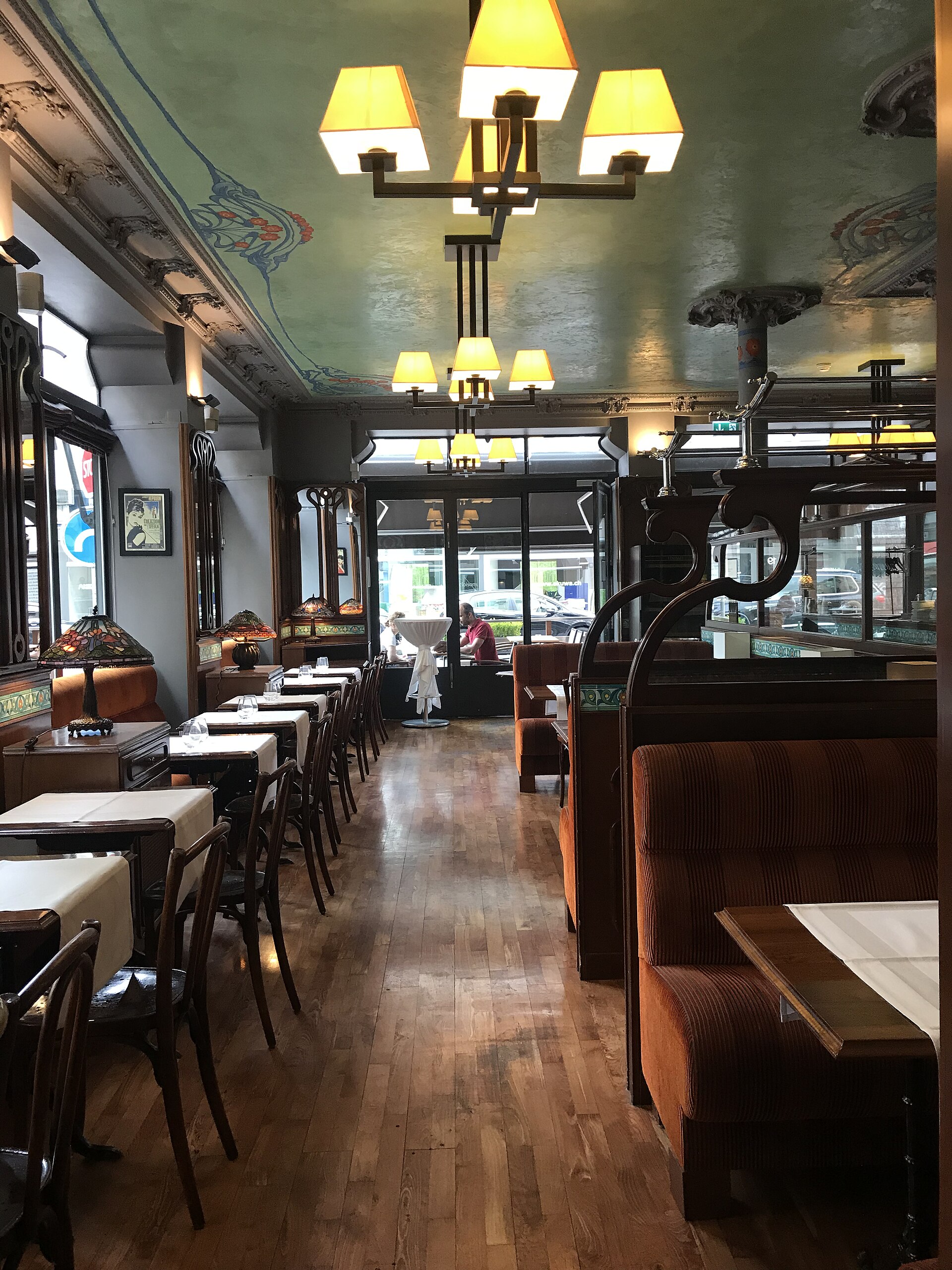 Tiffany Hôtel's restaurant in Geneva has upholstered booths, wooden floors, stained-glass lamps and a painted decorative ceiling.