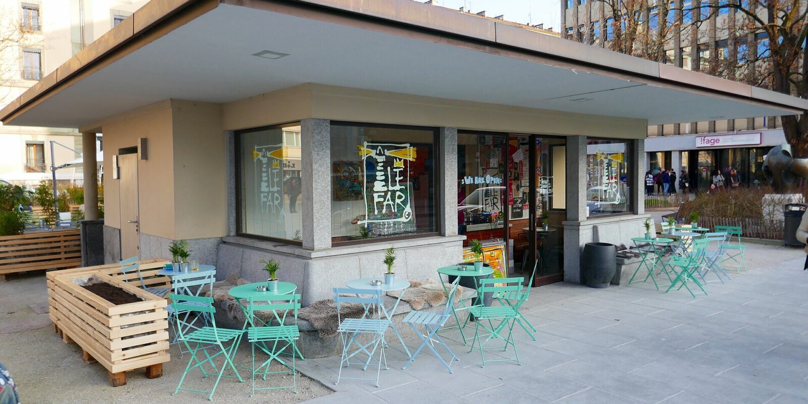 Turquoise tables and folding chairs surround the restaurant kiosk at Place des Augustins in Geneva.