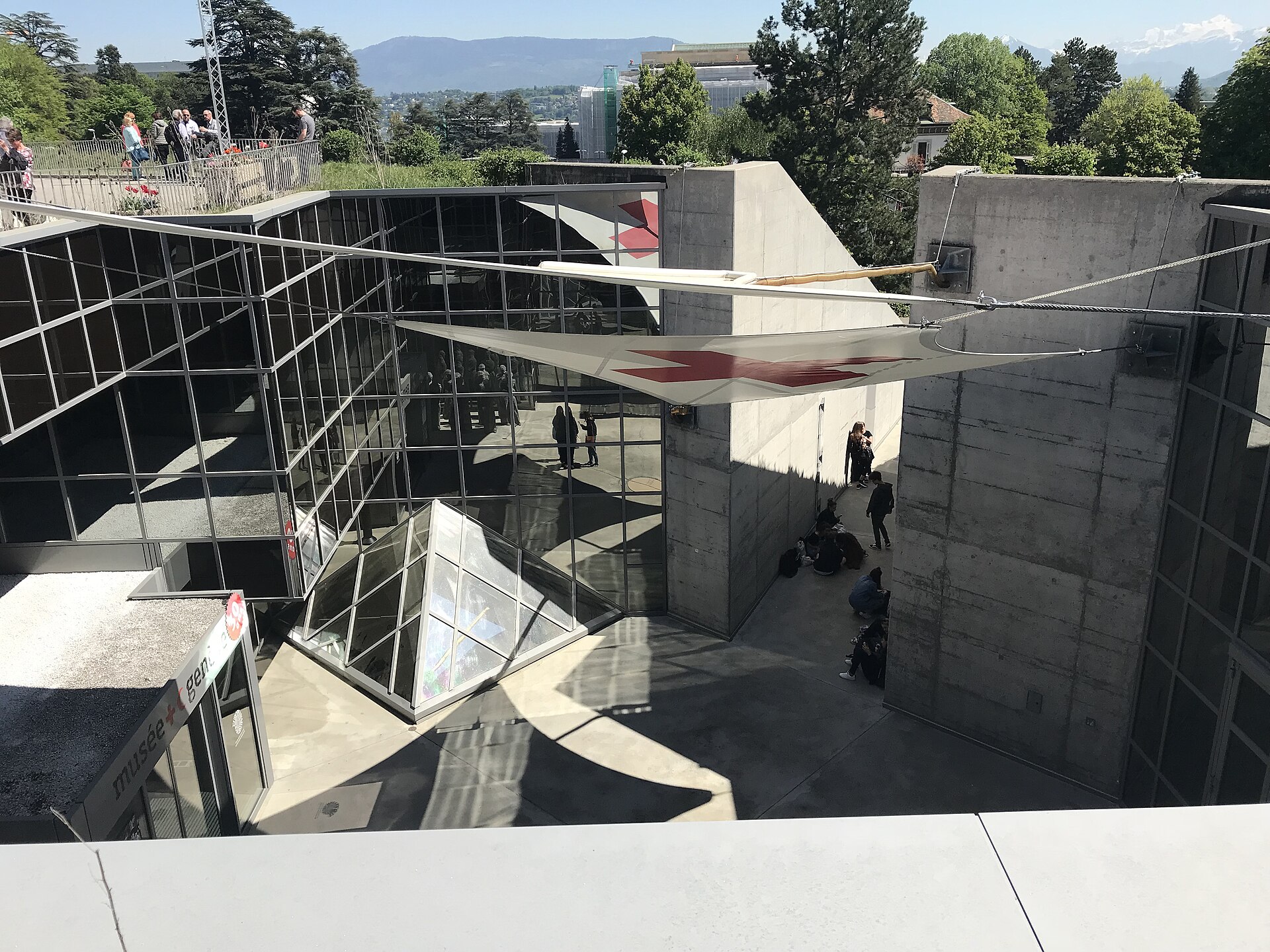 Visitors gather beneath a Red Cross canopy in the sunken courtyard of Geneva's International Red Cross and Red Crescent Museum.